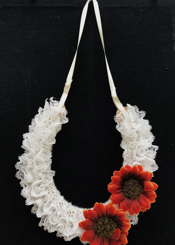 White lace horseshoe with two dark small sunflowers