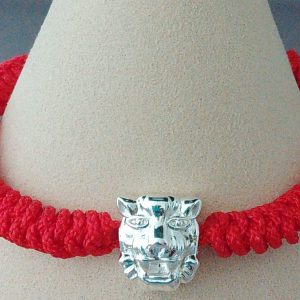 A hand knotted red coloured bracelet with Tiger Charm