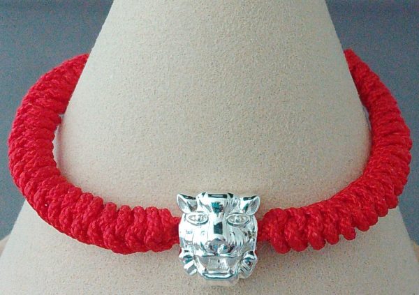 A hand knotted red coloured bracelet with Tiger Charm