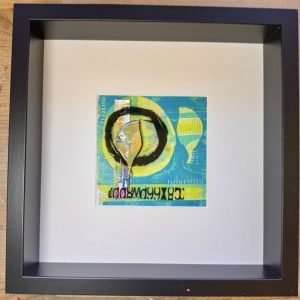 Mixed media collage featuring gel plate printing, acetate layers and upcycled elements. Framed in a deep shadow box black frame